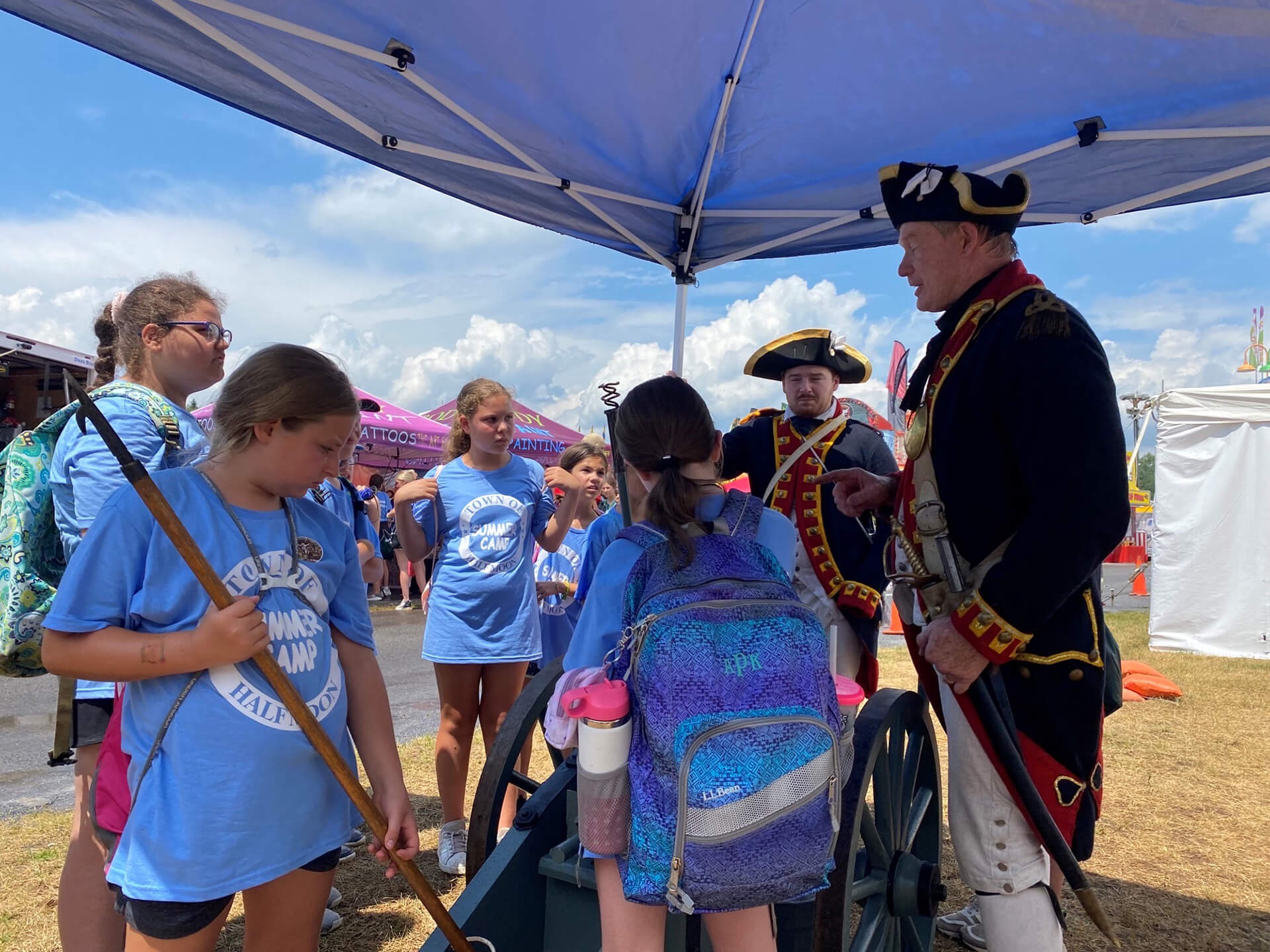 Revolutionary War reenactors talking to young school children