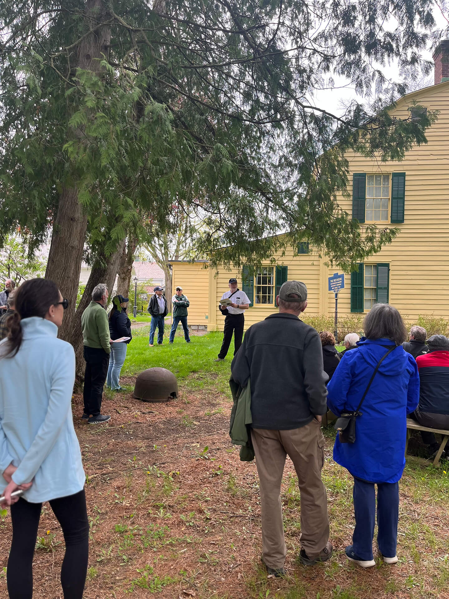 A group gathered at the The Schuyler House listening to a tour guide