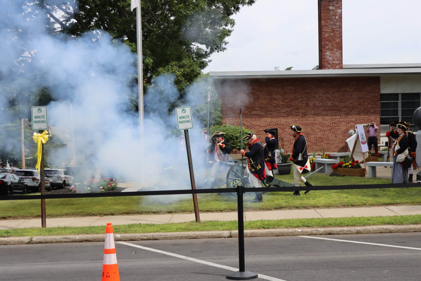Revolutionary War reenactors firing historical cannons during a press conference