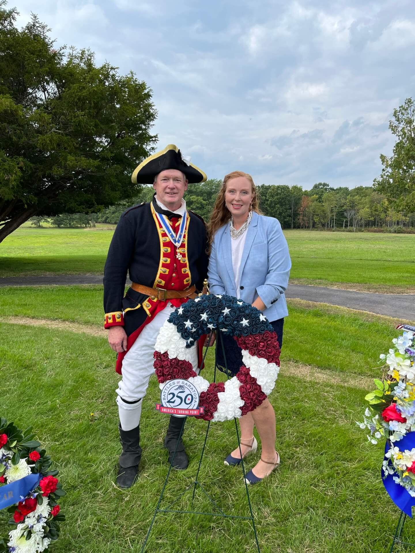 Two people standing infront of wreath