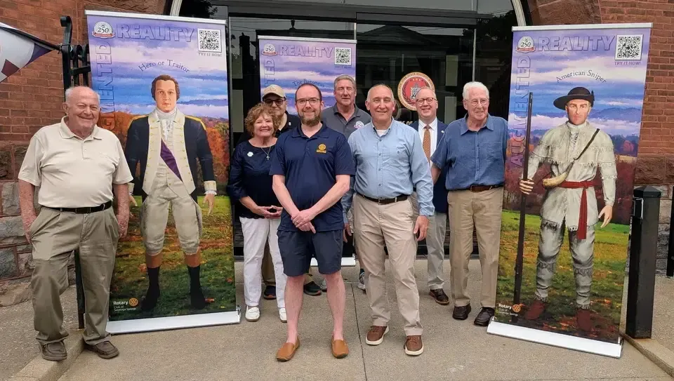 Saratoga 250 board members Phil Klein, from left, Corinne Scirocco, Vinnie Asaro, Rotary Club president; Dan Klein, Jay Rifenbary, Saratoga 250; Richard Goldenberg, director of Military History, Mark O’Rourke, president of Board of Trustees of the Friends of the New York State Military Museum; and Charles W. Wheeler, Jr., trustee of Friends of the New York State Military Museum, stand in front of banners of historical figures. Show Less Courtesy of Adam Mason for the Friends of New York State Military Museum