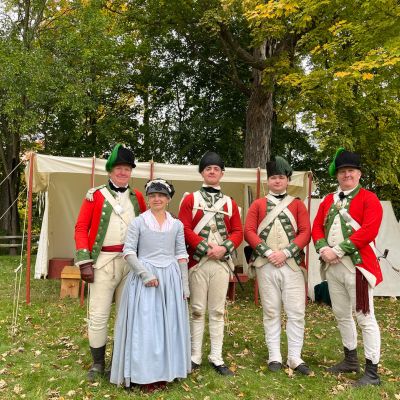 Revolutionary War reenactors in a field with tents