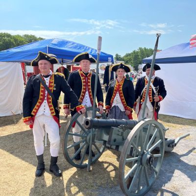 Revolutionary War reenactors standing around a cannon